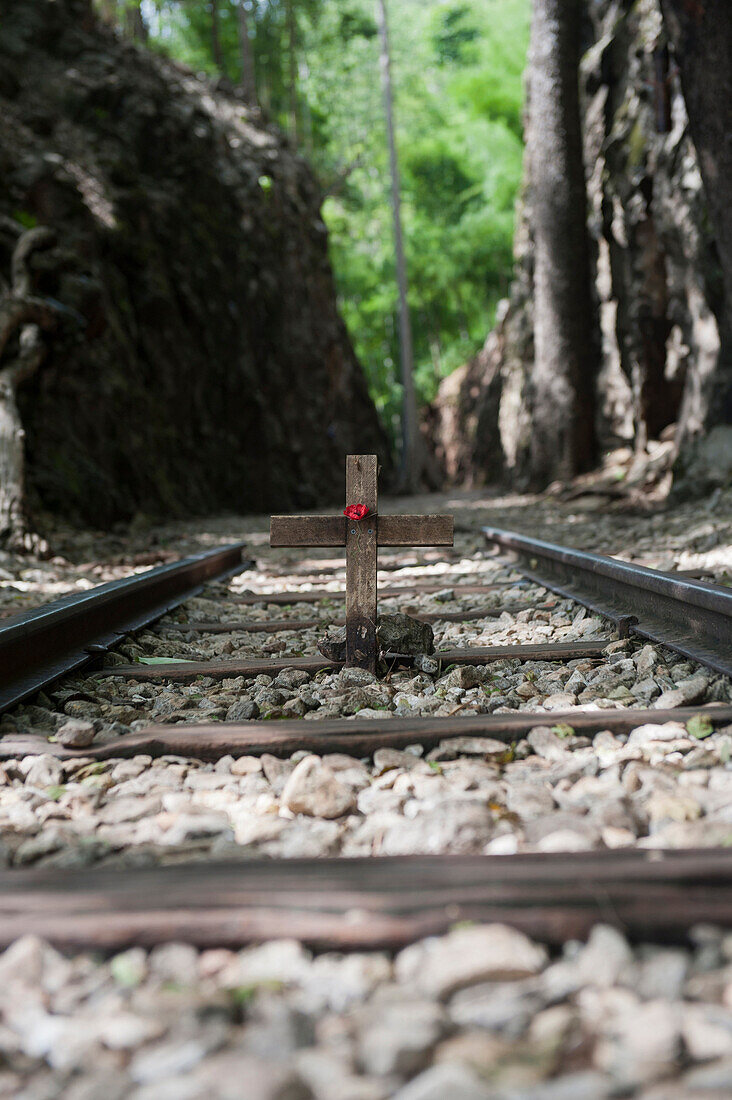 Death Railway, remembrance wooden cross and red poppy along a section of railway at the Hellfire Pass railway cutting, Kanchanaburi. Thailand