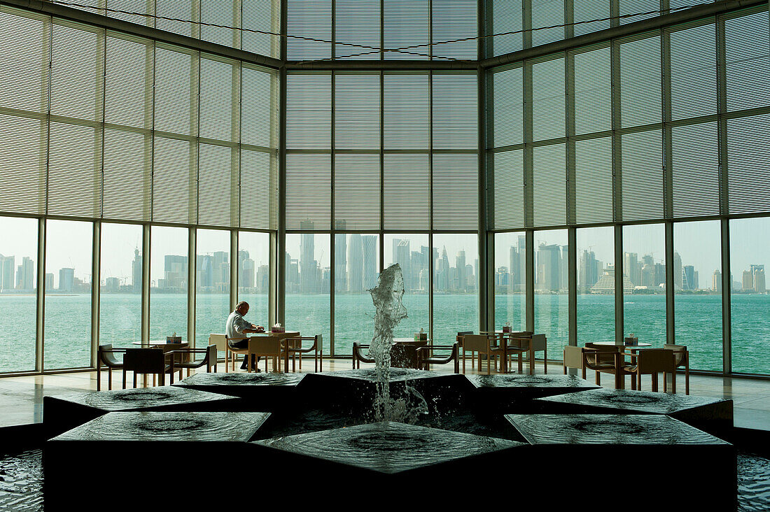 Man and fountain in front of large window in the Museum of Islamic Art, Doha, Qatar