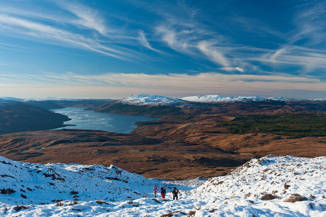 Walkers climbing up snow-covered Beinn Respiol, Ardnamurchan peninsula, Highlands, Scotland