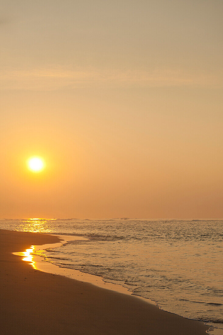 Looking along beach to rising sun, near Unawatuna, Thalpe, Sri Lanka