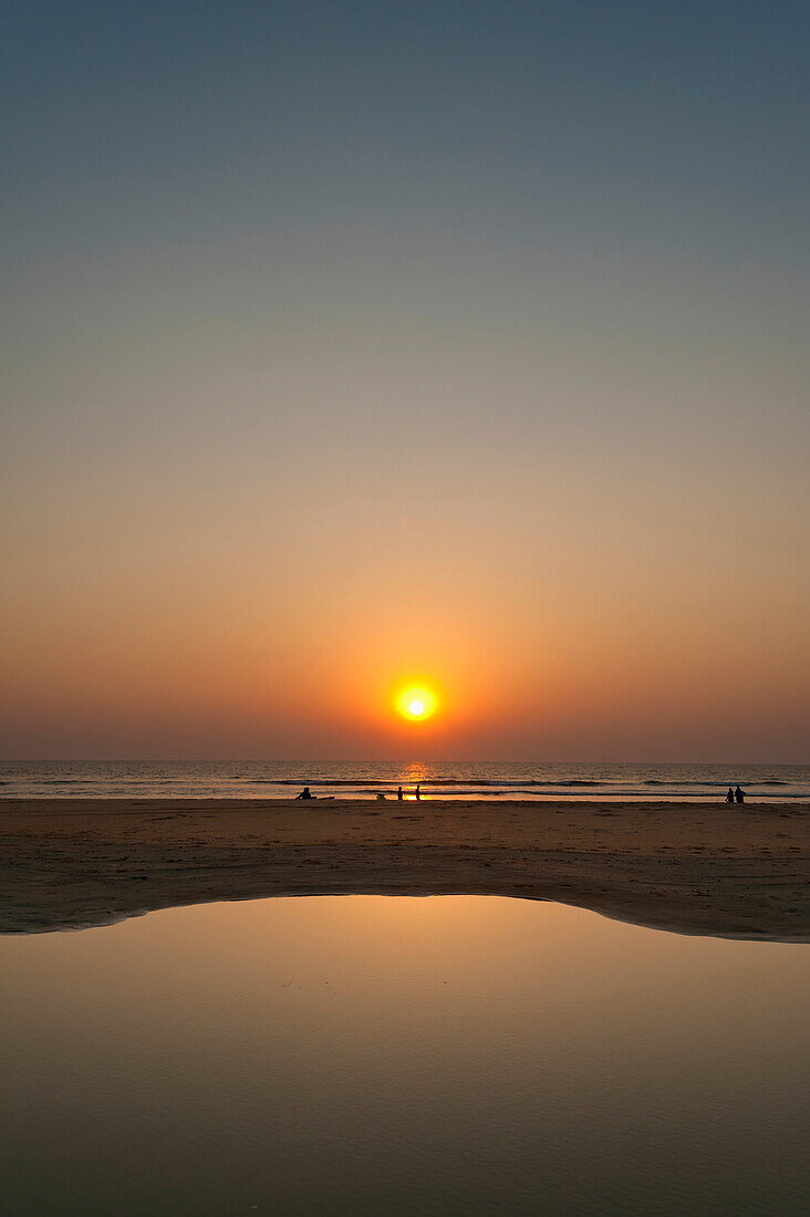 Calm pool of water at dusk on beach, Goa, India