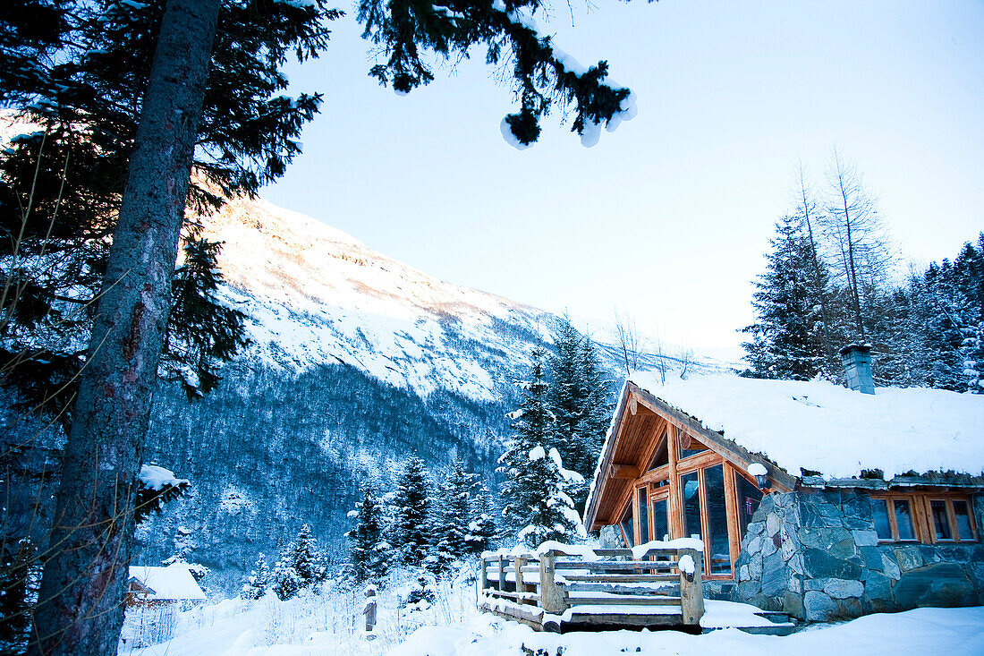 Winter alpine scenery with mountains, snow and a pine forest with Brekke rental cabins, Ortnevik, Sognefjord, Norway