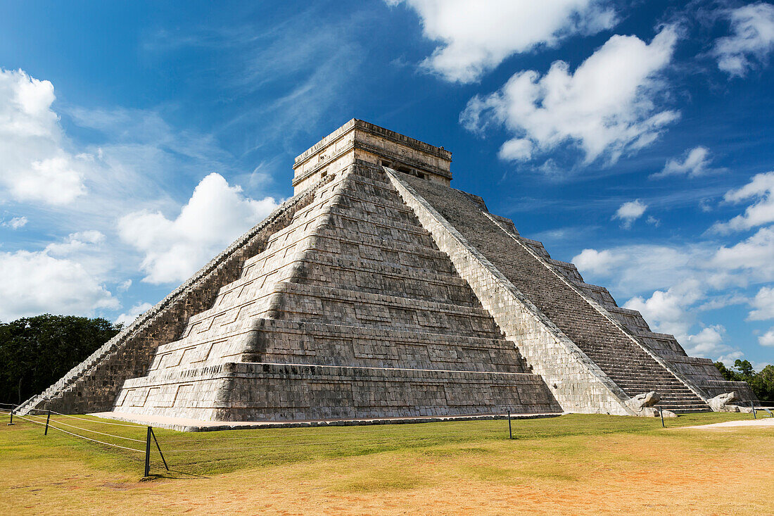 'Ancient Mayan Pyramid with two large serpent heads with their mouths open and white clouds and blue sky; Chichen Itza, Yucatan, Mexico'