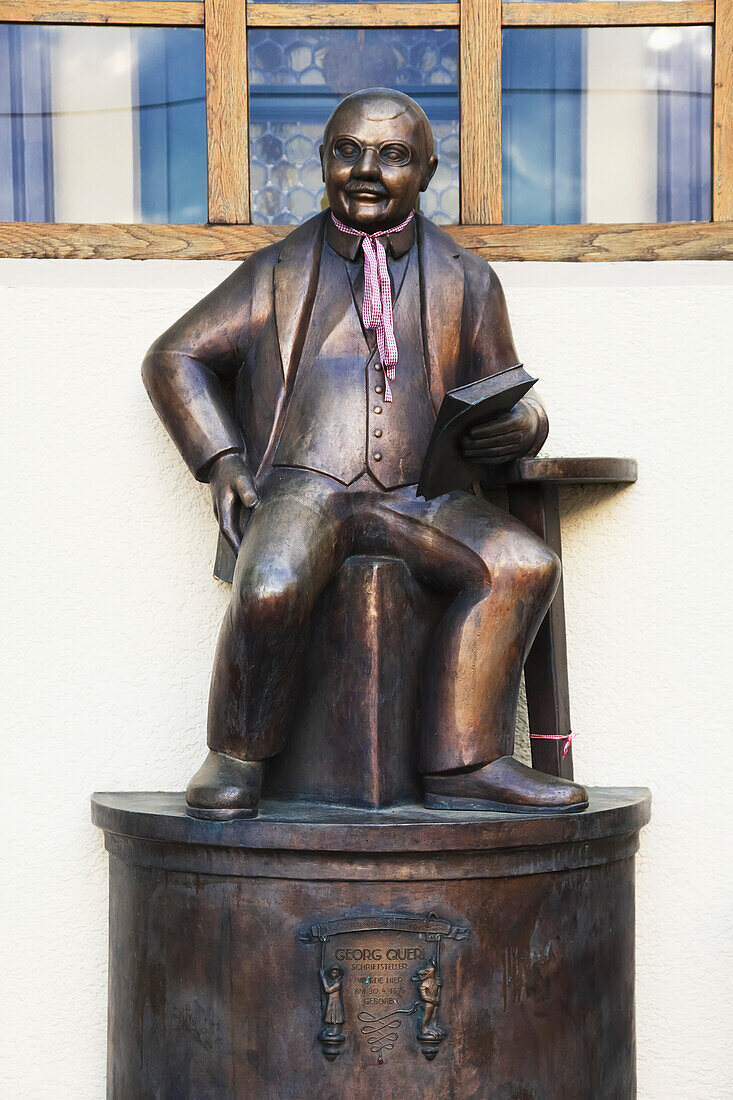 'Bronze statue of a man sitting and holding a book; Bayern, Germany'