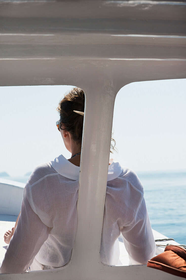 'A woman in a white shirt sits at the front of a boat with a view of the ocean; Ixtapa-Zihuatanejo, Guerrero, Mexico'