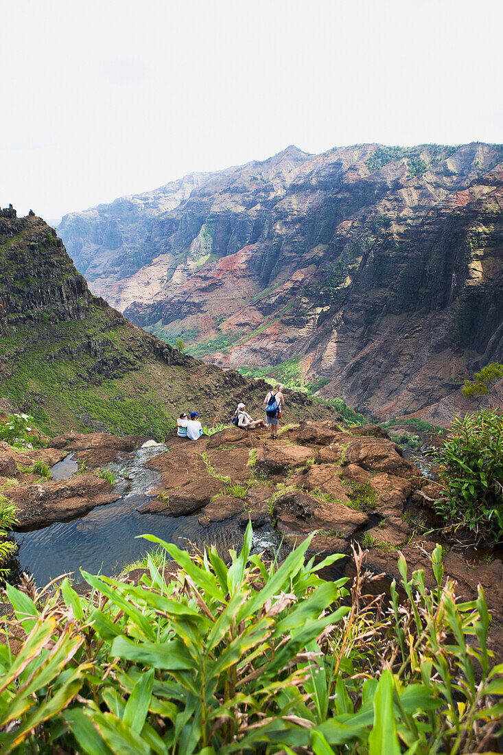 'A family overlooks the breathtaking views over Waimea Canyon; Kauai, Hawaii, United States of America'