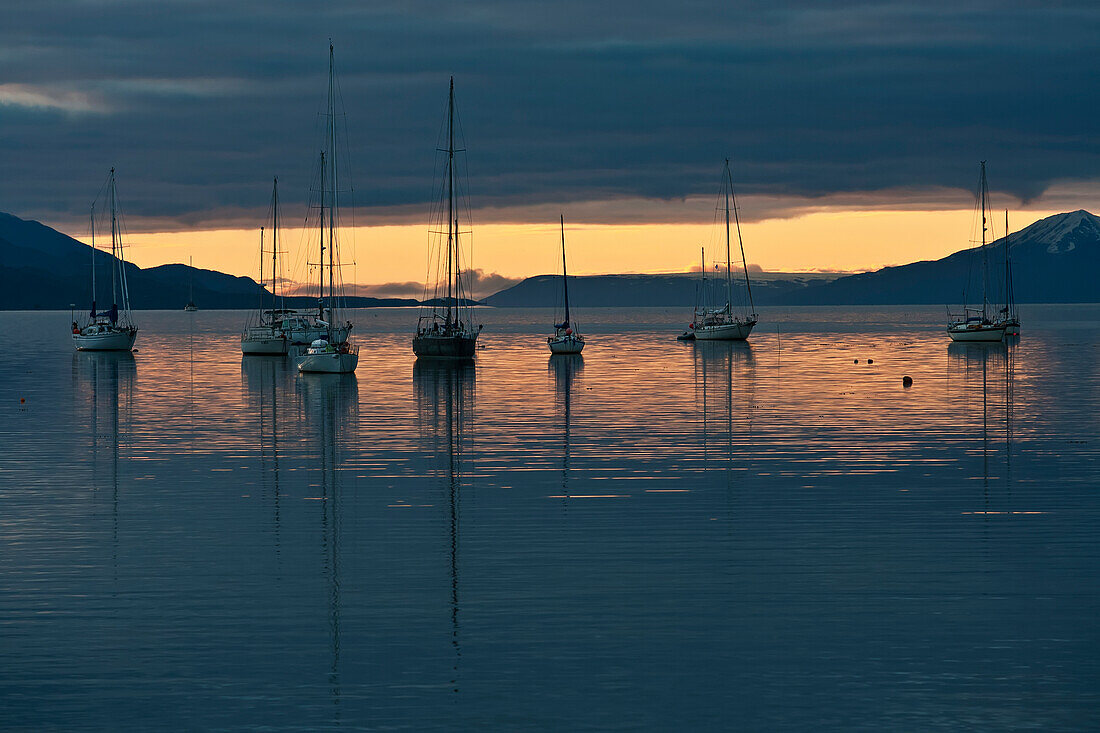 Sunset over the water with sailboats moored in the foreground, Ushuaia, Patagonia, Argentina