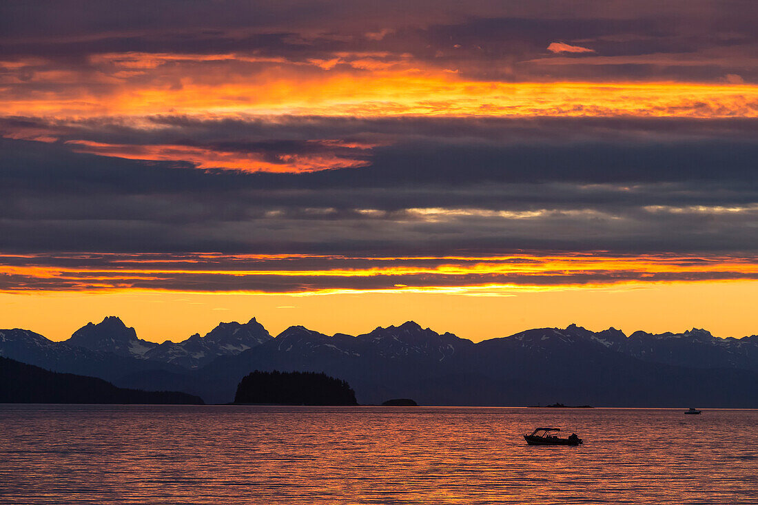 Scenic sunset view of Favorite Passage, Chilkat Mountains, and a silhouetted fishing boat, Inside Passage, Southeast Alaska