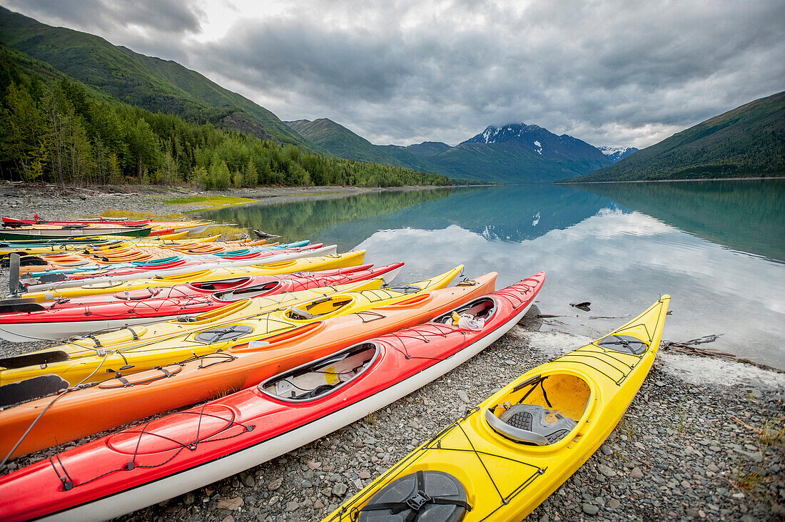 Kayaks in a row on shore at Eklutna Lake, Chugach Mountains, Southcentral Alaska.