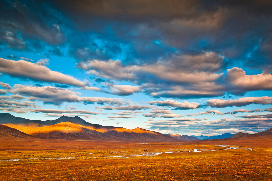 Evening light on Brooks Range with the Chandalar River meandering through colorful tundra in the foreground, Gates of The Arctic National Park & Preserve, Arctic Alaska, Autumn.