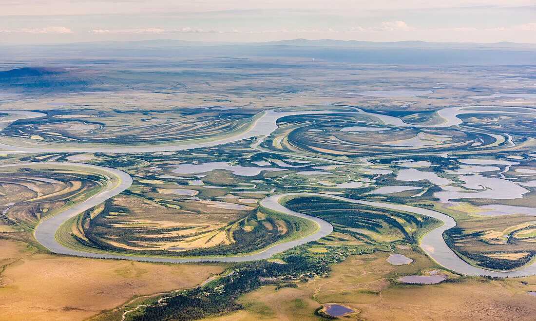 Aerial view of the Kobuk River and surrounding wetlands with the Baird Mountains visible in the background, Arctic Alaska, summer