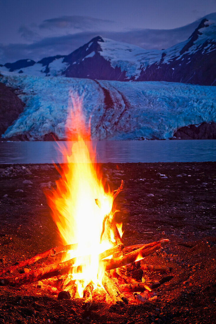 Close up of campfire in front of Portage Glacier at dusk, Chugach National Forest, Kenai Peninsula, Southcentral Alaska, Summer.