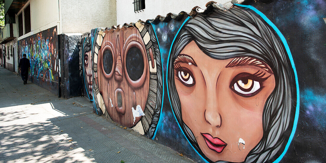 Faces painted on a wall lining a walkway, Santiago, Santiago Metropolitan Region, Chile