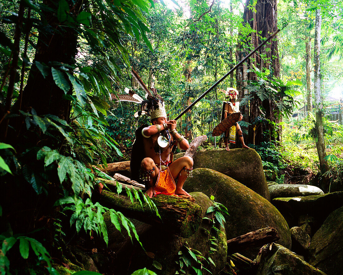 Sarawak men dressed in traditional attire with blowpipes, Sarawak