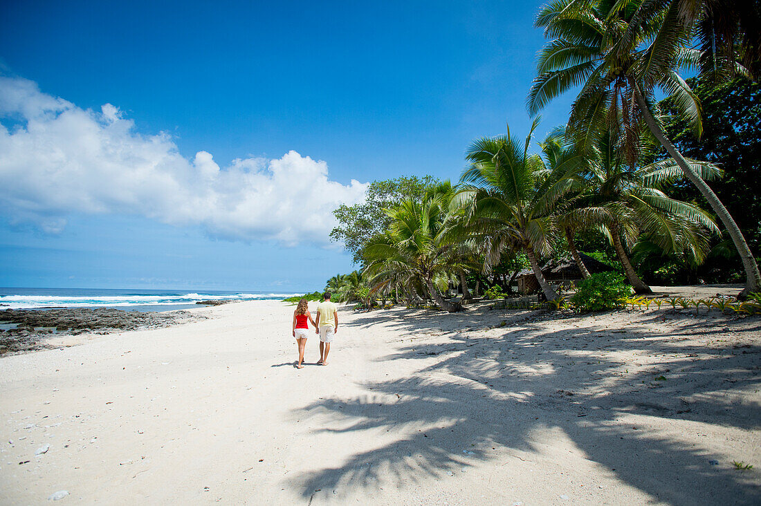 Tourists walking along the beach, Tanna Island, Vanuatu