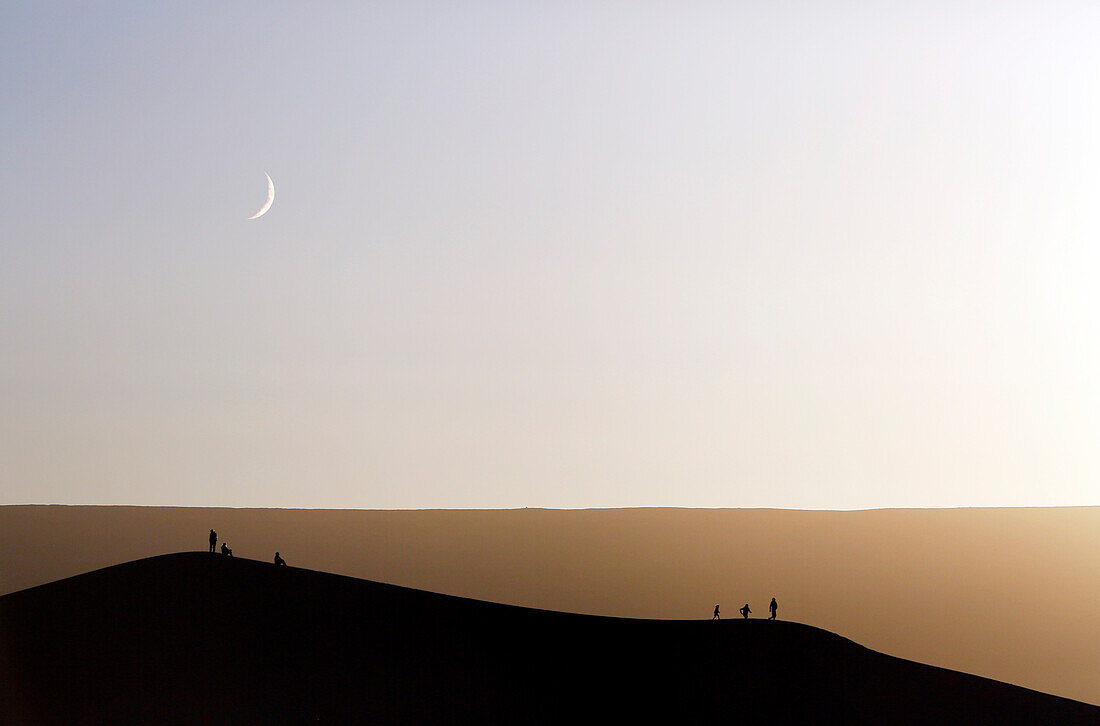 Morocco, Draa Valley, Tinfou, Tinfou dunes, Tourists on the dunes at sunset, Crescent moon