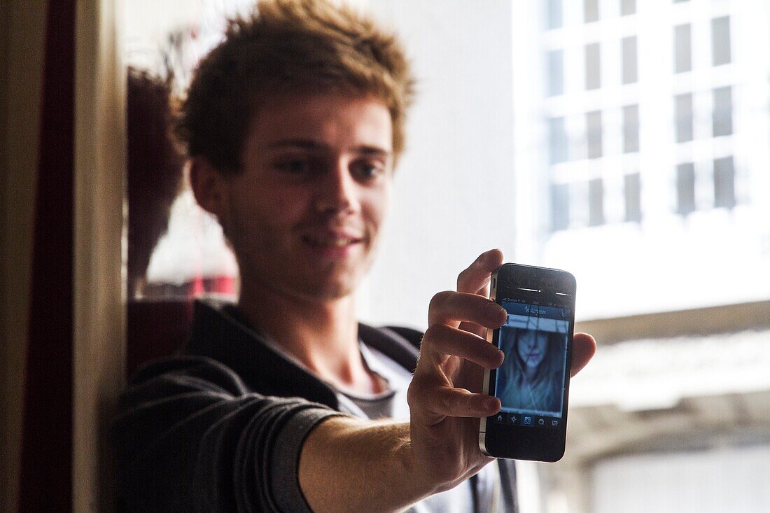 Teenager showing the picture of a girl on his phone