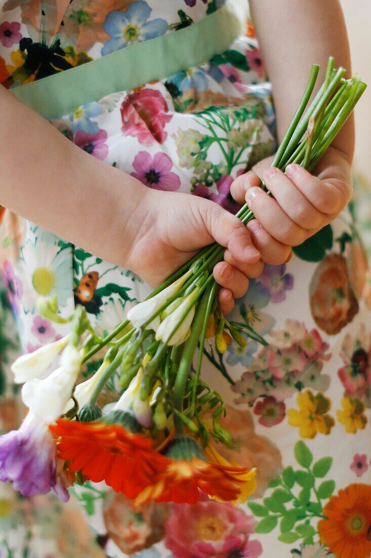 Closeup on hands of a little girl holding a flower bouquet
