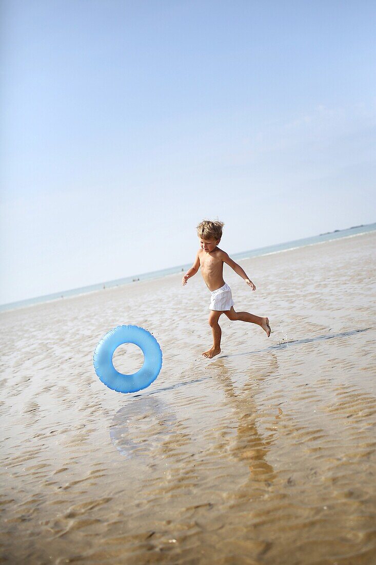 Little boy at the beach with his rubber ring