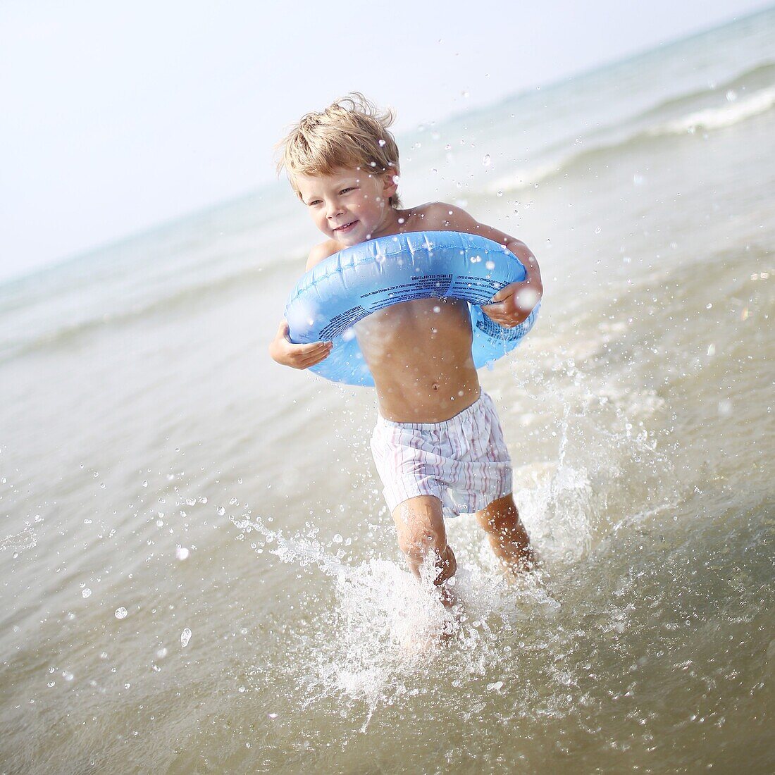 Little boy at the beach with his rubber ring