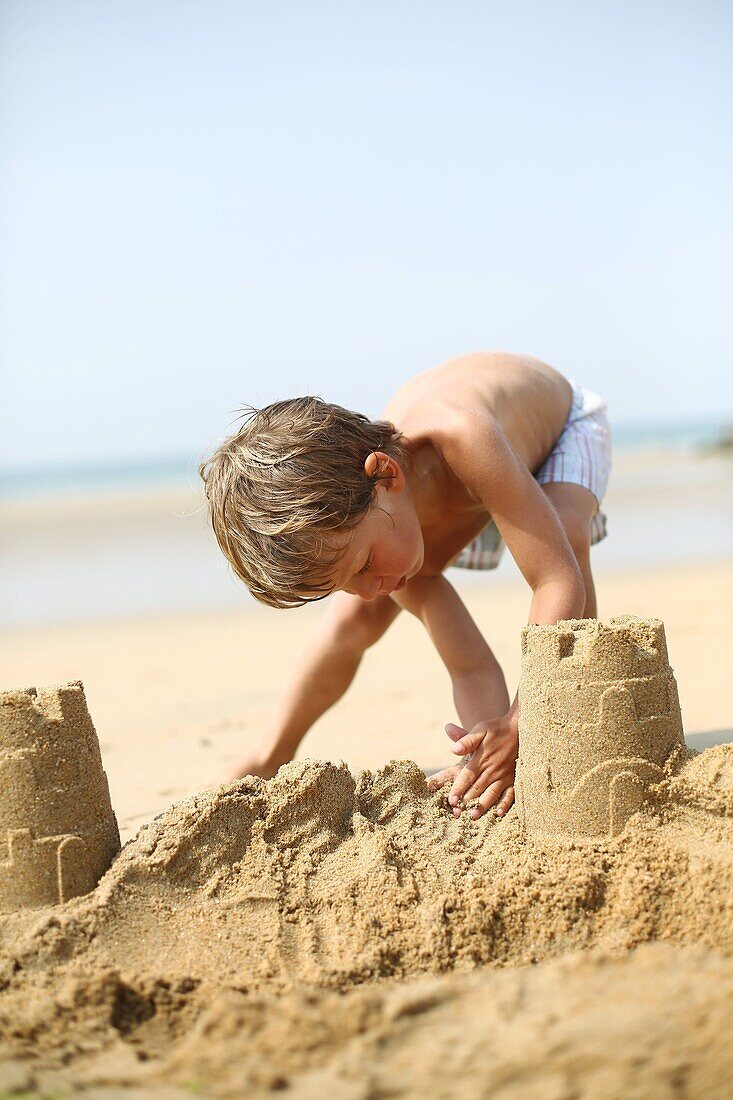 Little boy making a sand castle on the beach