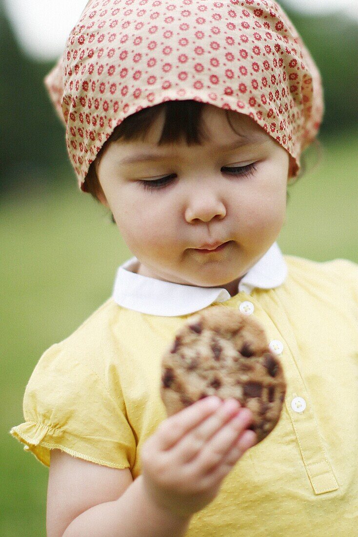 Little girl eating chocolate cookie