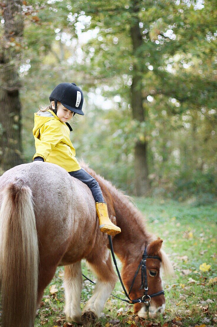 Little girl riding a pony