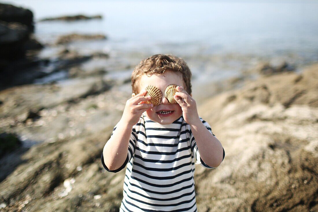 3 years old boy making eyes with shellfish