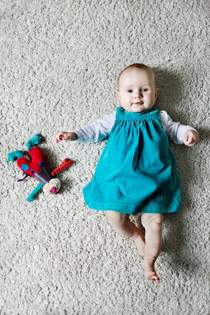 Portrait of a 4 months baby girl liying on the floor