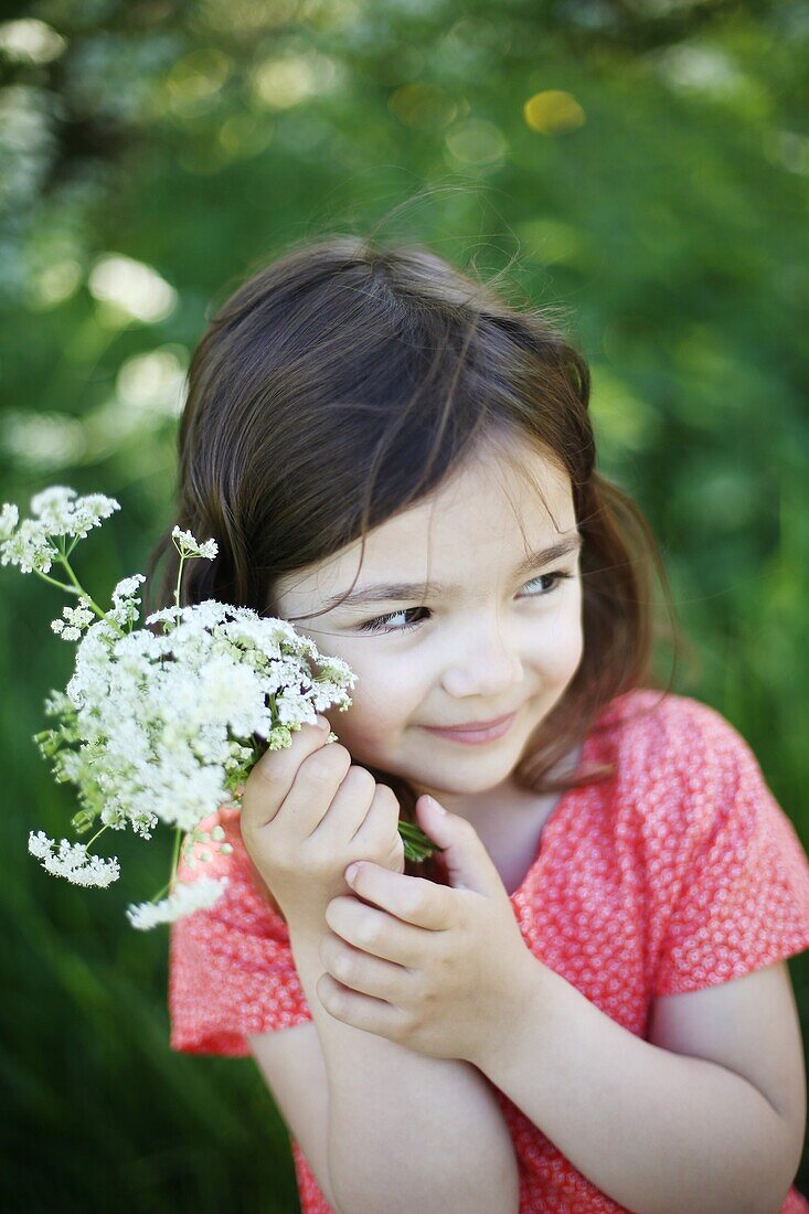 A 5 years old girl with flowers in the countryside