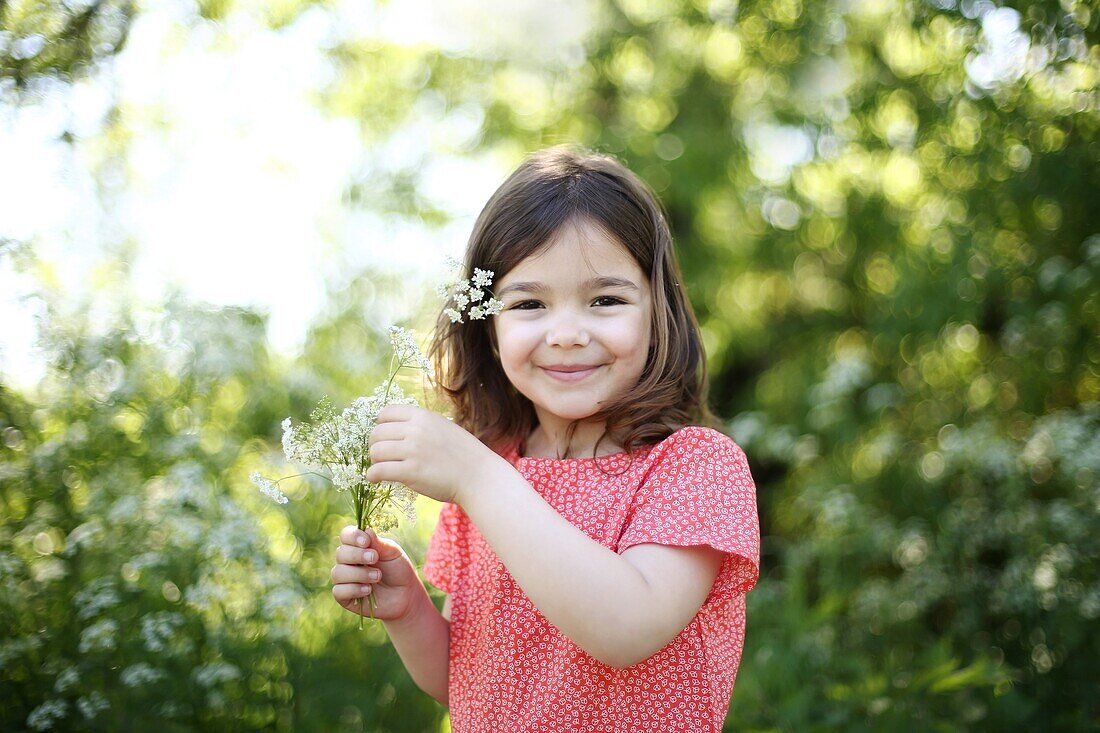 A 5 years old girl with flowers in the countryside