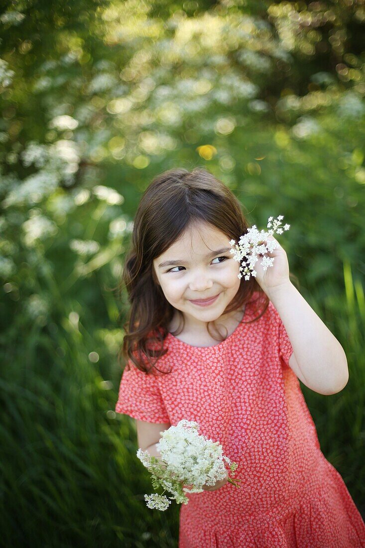 A 5 years old girl with flowers in the countryside