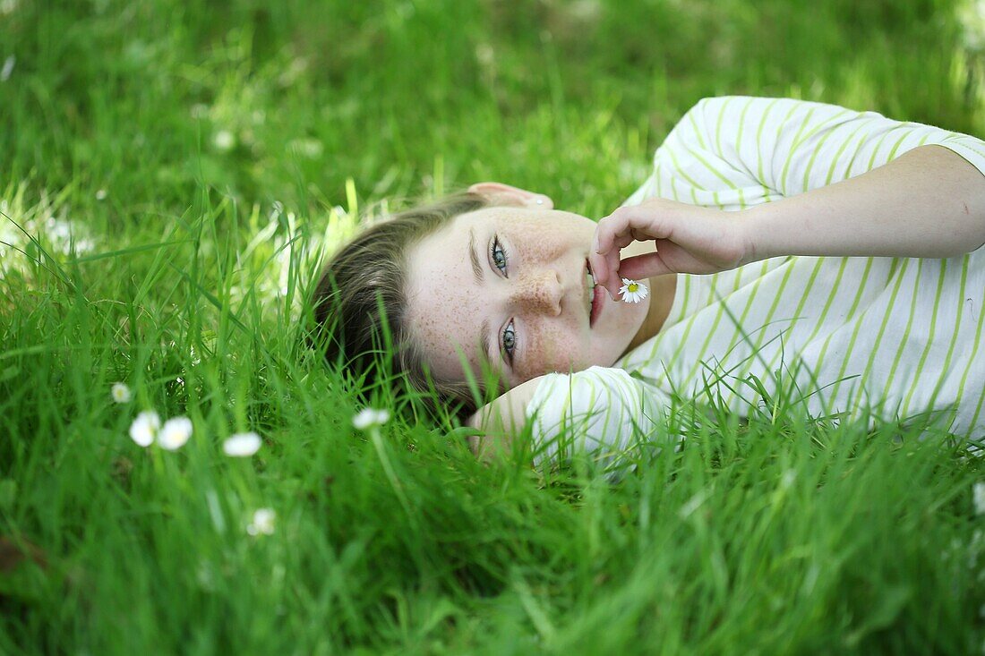 Portrait of a 9 years old girl elongated in the grass