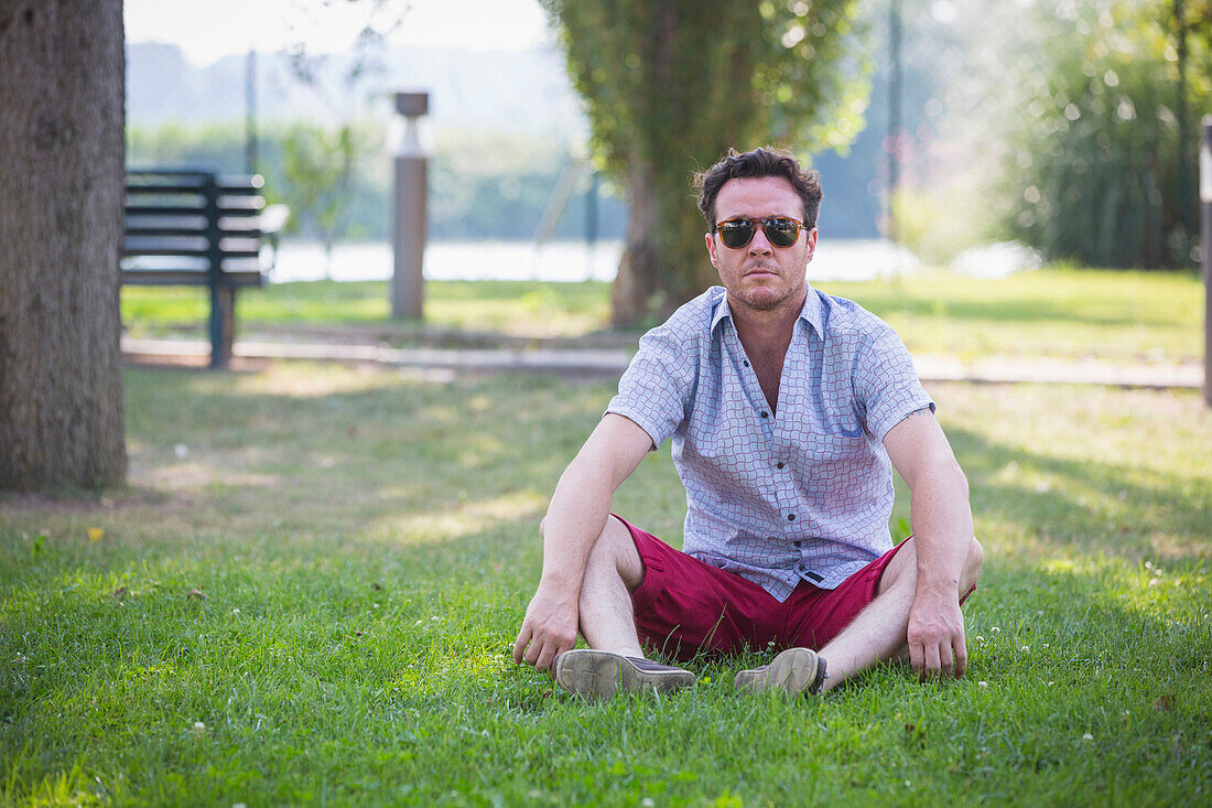 Caucasian man sitting in grass in park
