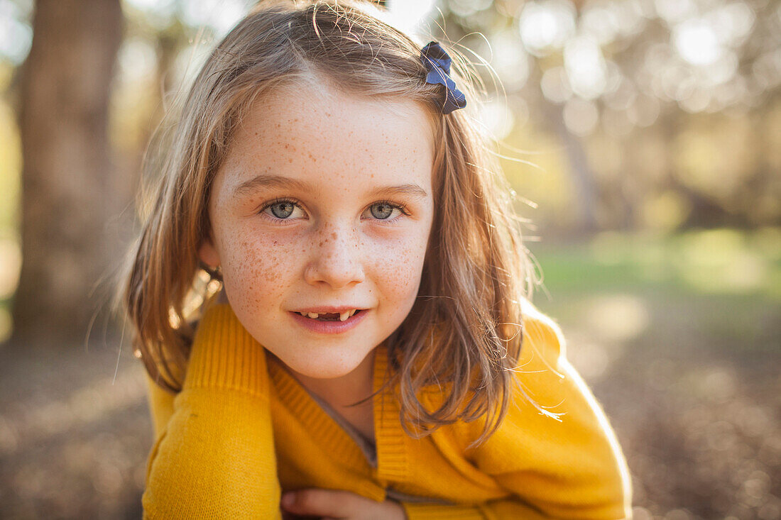 Close up of smiling girl laying in field