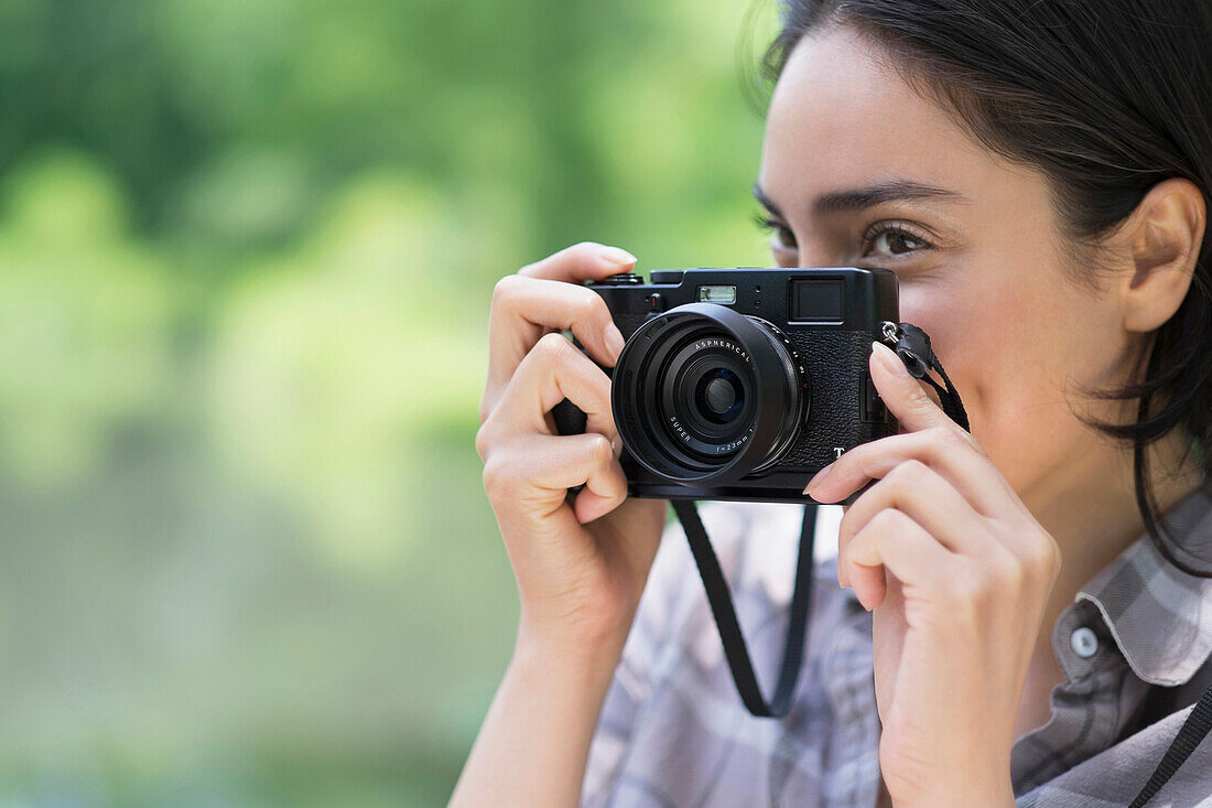 Hispanic woman photographing outdoors