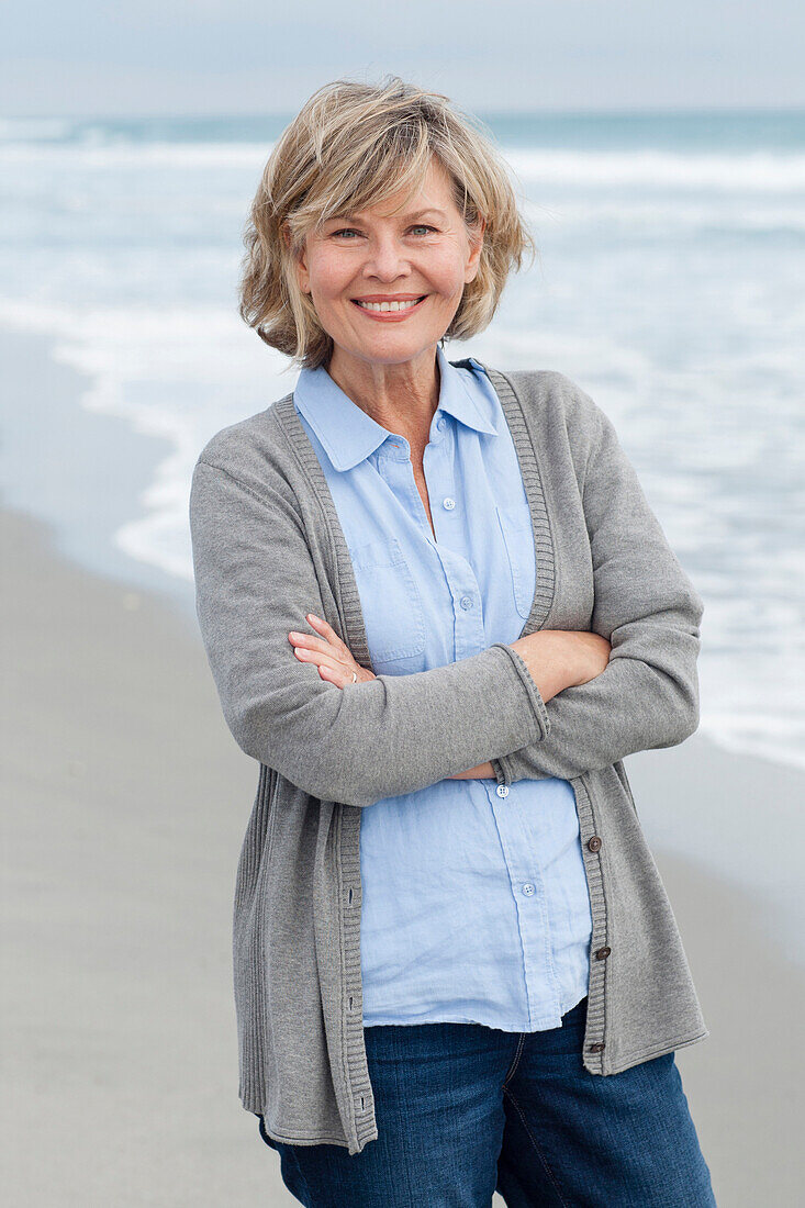Smiling Caucasian woman standing on beach