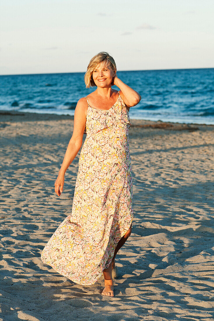Smiling Caucasian woman walking on beach