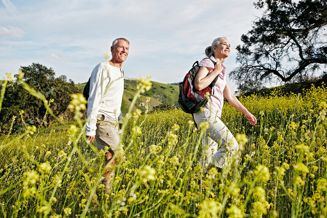 Caucasian couple hiking in tall grass