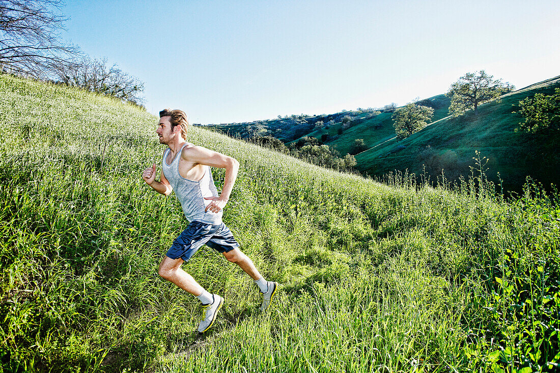 Caucasian athlete running on rural trail