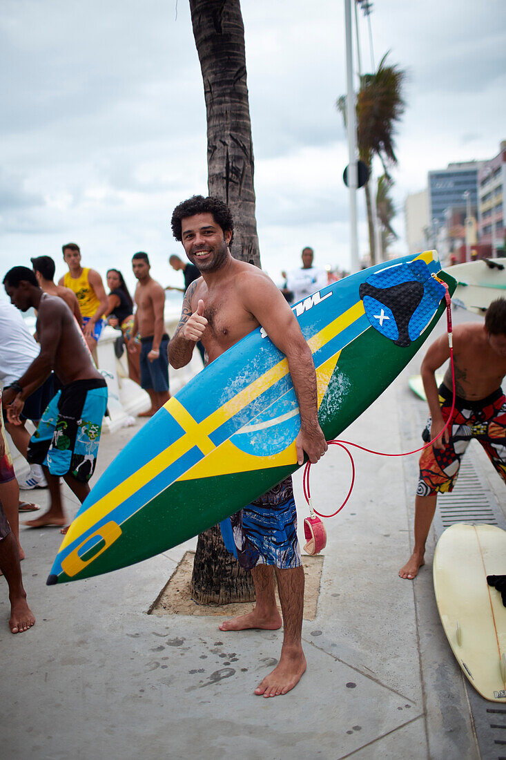 Santos is half Swedish, standing on the boardwalk after surfing, Avenida Oceanica, Barra, Salvador de Bahia, Bahia, Brazil