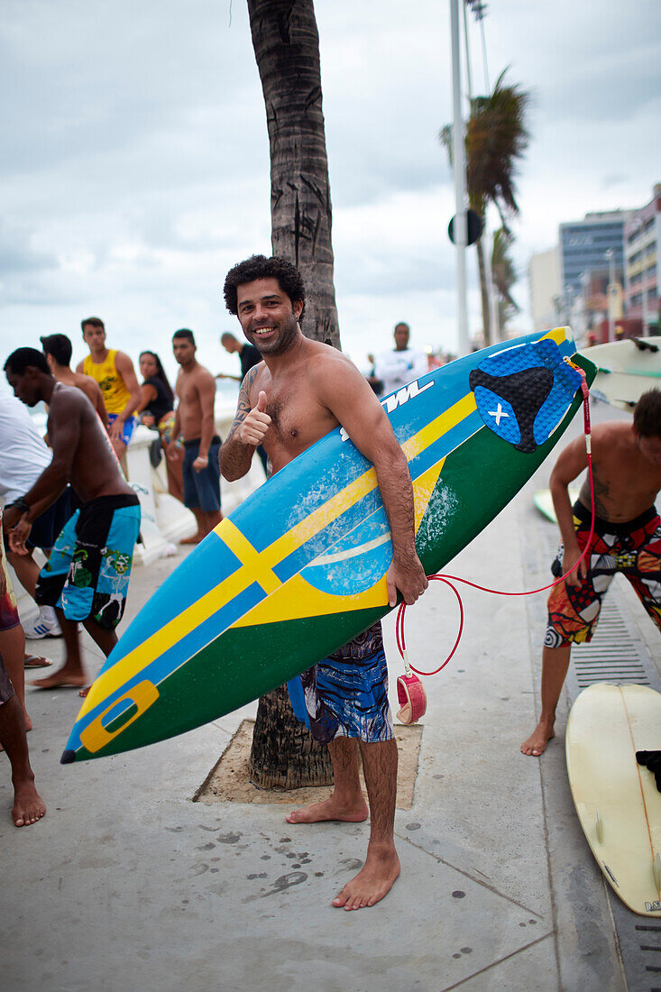 Santos ist Halbschwede, steht an Promenade nach dem Surfen, Avenida Oceanica, Barra, Salvador de Bahia, Bahia, Brasilien