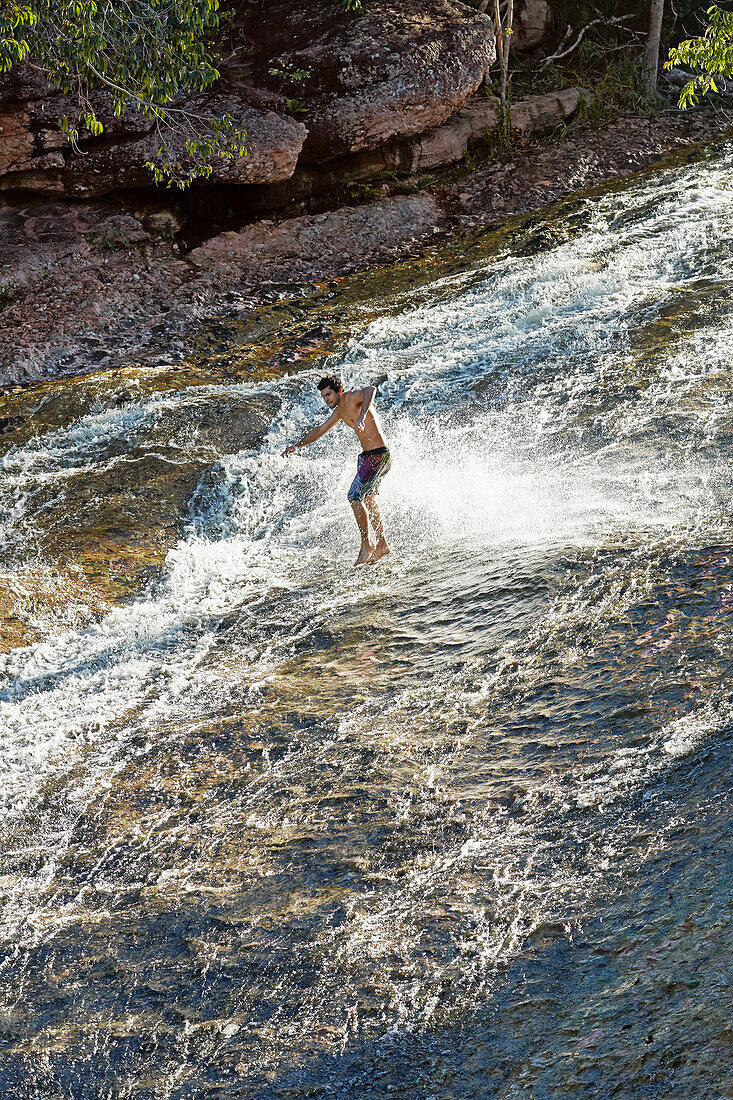 Wasserfall-Surfer, Steinrutsche, des Flusses Rio Ribeirao do Meio, Männer aus dem Dorf rutschen stehend auf Fusssohlen, bei Lencois, Hauptort, Ausgangspunkt fuer Chapada Diamantina National Park,  Bahia, Brasilien