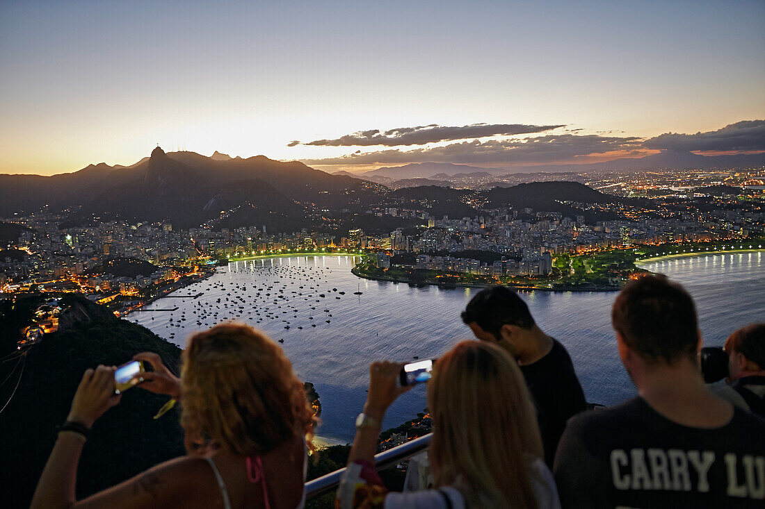 Besucher fotografieren, Blick abends vom Zuckerhut nach Westen, ueber Bucht Enseada de Botafogo, Rio de Janeiro, Rio de Janeiro, Brasilien