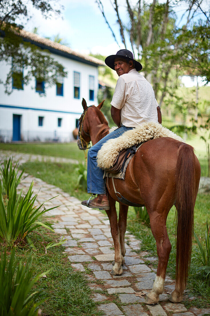 Gaucho, offers horse riding for guests of Fazenda Catucaba, old farm from 1850 is now also a luxurious hotel, located in the coastal mountains, Parque Serra do Mar in Sao Luiz do Paraitinga, Sao Paulo, Brazil
