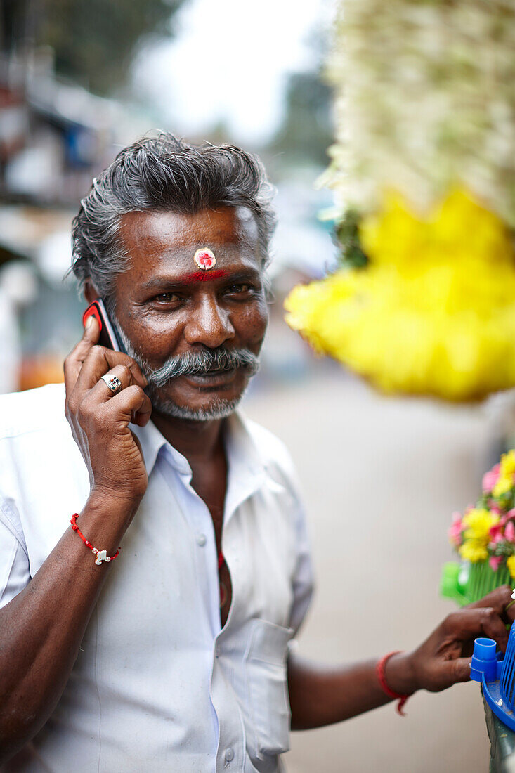 Hindu, Kunde an Blumenstand auf dem Markt, in Valparai, Tamil Nadu, Western Ghats, Indien
