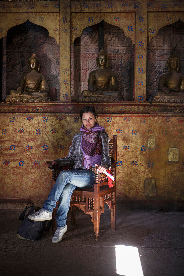 Caucasian woman sitting in chair in temple