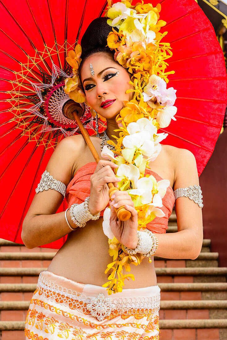 Asian woman with flower headdress holding parasol