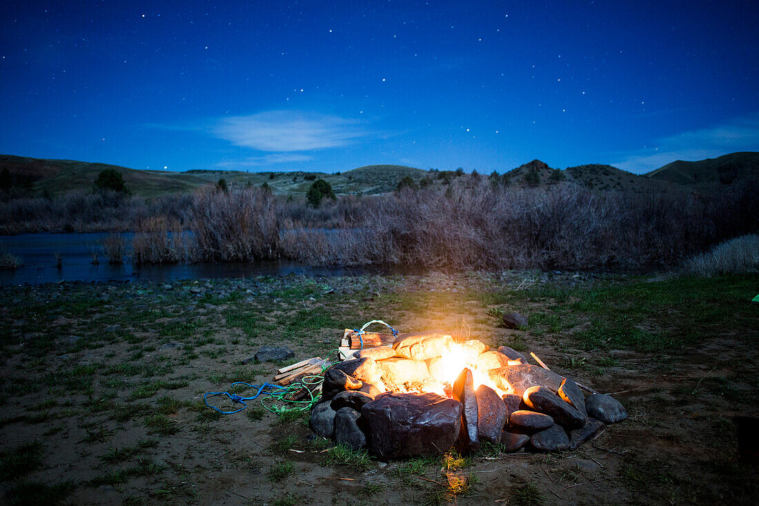 Burning campfire in remote field, Painted Hills, Oregon, United States