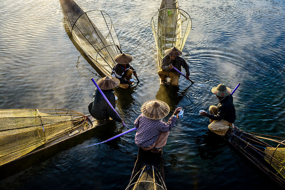 High angle view of Asian fishermen fishing in canoes on river